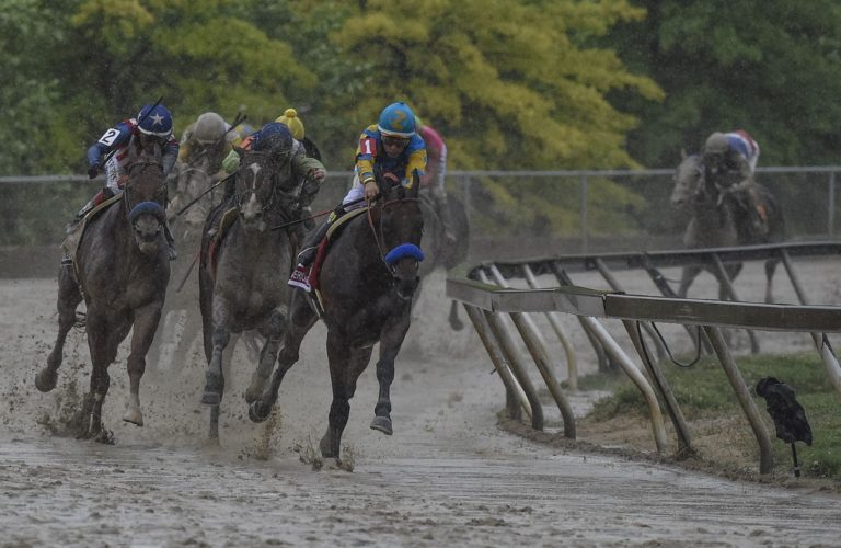 American Pharoah dominates down the stretch on a muddy Preakness track